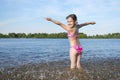 Happy little girl playing with water on the river bank, on a sunny day Royalty Free Stock Photo