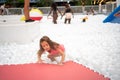 Happy little girl playing white plastic balls pool in amusement park. Royalty Free Stock Photo