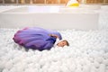 Happy little girl playing white plastic balls pool in amusement park. playground for kids Royalty Free Stock Photo