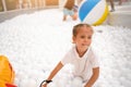 Happy little girl playing white plastic balls pool in amusement park. playground for kids Royalty Free Stock Photo