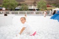 Happy little girl playing white plastic balls pool in amusement park. playground for kids Royalty Free Stock Photo