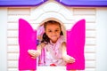 Happy little girl plays in the amusement park. Joyful child on vacation. Portrait of a girl on attractions Royalty Free Stock Photo