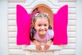 Happy little girl plays in the amusement park. Joyful child on vacation. Portrait of a girl on attractions Royalty Free Stock Photo