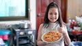 Happy little girl preparing homemade pizza in the home kitchen Royalty Free Stock Photo