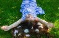 Happy little girl, pretty little girl lying on grass with flowers Royalty Free Stock Photo