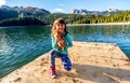 Happy little girl with a puppy by the Black Lake ( Crno jezero),Durmitor, Montenegro Royalty Free Stock Photo