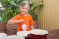 Happy little girl puts cereal in a bowl