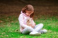 Happy little girl with a rabbit in her hands in the park Royalty Free Stock Photo