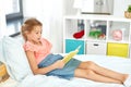 Happy little girl reading book at home Royalty Free Stock Photo