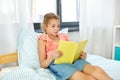 Happy little girl reading book at home Royalty Free Stock Photo