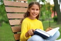 Happy little girl reading book in park Royalty Free Stock Photo