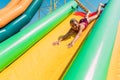 Happy little girl rides a water inflatable slide in a water Park, summer Sunny day, entertainment, water Park Royalty Free Stock Photo
