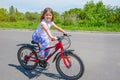 Happy little girl riding her bike in the park. The concept of a healthy lifestyle