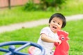 Happy little girl riding red chicken at the playground.