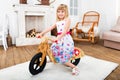 Happy little girl riding a runbike at home Royalty Free Stock Photo