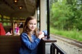 Happy little girl riding a train in a theme park or funfair Royalty Free Stock Photo