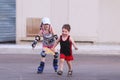 Happy little girl roller skates on asphalt and boy Royalty Free Stock Photo