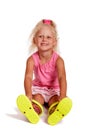 Happy little girl in rubber boots sitting on the floor isolated Royalty Free Stock Photo