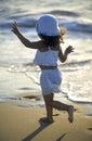 Happy little girl running along the sea on the beach Royalty Free Stock Photo