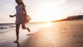 Happy little girl running on the beach at sunset - Kid having fun in holiday vacation with back sun light - Youth, lifestyle and Royalty Free Stock Photo