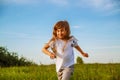 Happy little girl running on green field at the summer day. Royalty Free Stock Photo