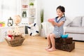 Happy little girl sailor sitting on retro suitcase