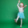 Happy little girl in Santa Claus hat jumping Royalty Free Stock Photo