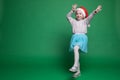 Happy little girl in Santa Claus hat jumping Royalty Free Stock Photo