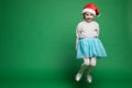 Happy little girl in Santa Claus hat jumping Royalty Free Stock Photo