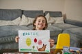 Happy little girl showing her beautiful drawing to the camera, Easter theme Royalty Free Stock Photo