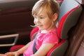 Happy little girl sitting in baby car seat Royalty Free Stock Photo