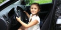 Happy little girl sitting behind the wheel of dad`s car Royalty Free Stock Photo