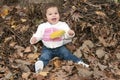 Happy little girl sitting in leaves