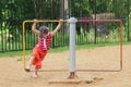 Happy little girl in skirt whirls on roundabout