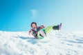 Happy little girl slides down from the snow slope. Enjoying the Royalty Free Stock Photo