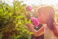 Happy little girl smelling fragrant pink peonies Royalty Free Stock Photo