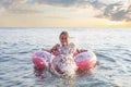 Happy little girl splashing in sea waves on sea and sky clouds background Royalty Free Stock Photo