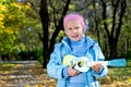 Happy little girl strumming a toy guitar