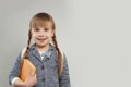 Happy little girl student smiling on white background with copy dpace. Child with school bag and book. Back to school concept Royalty Free Stock Photo