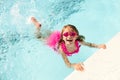 Happy little girl swimming holding on to pool edge Royalty Free Stock Photo