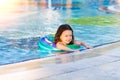 Happy little girl swimming in the pool with inflatable ring on a Sunny summer day. Kids learn to swim. Family vacation Royalty Free Stock Photo