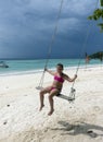 Happy little girl on swing at the beach Royalty Free Stock Photo