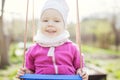 Happy little girl on swing in garden