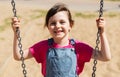 Happy little girl swinging on swing at playground Royalty Free Stock Photo