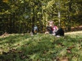 Happy girl with two dogs sitting on green grass having fun, family picnics, spending time together, hiking in mountains Royalty Free Stock Photo