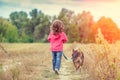 Little girl walking with dog on the field Royalty Free Stock Photo