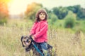 Little girl walking with dog on the field Royalty Free Stock Photo