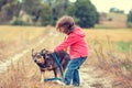 Little girl walking with dog in the field Royalty Free Stock Photo