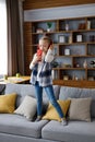 Happy little girl wearing red earphones dancing and singing using smartphone like microphone. Cute child having fun Royalty Free Stock Photo