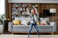 Happy little girl wearing red headphones dancing and singing, jumping on a floor. Cute child enjoy listening favorite Royalty Free Stock Photo